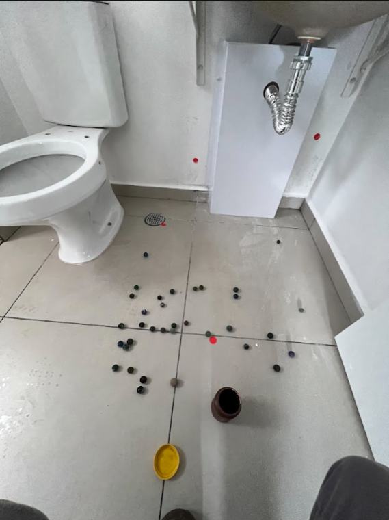 Piso de banheiro com marcações de vistoria, ralo e verificação de caimento