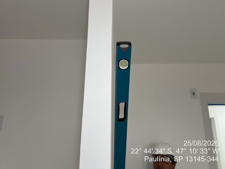 Nível de bolha verificando prumo de parede e viga